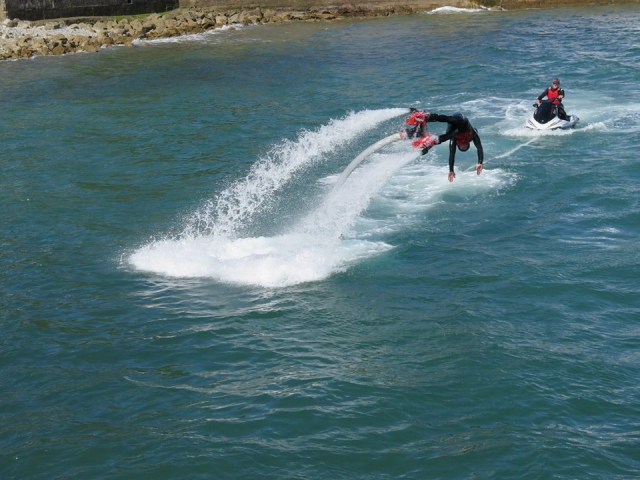 joven tirandose de cabeza al mar desde su plataforma de flyboard.jpg